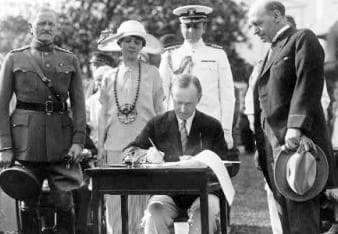 President Coolidge signing appropriation bills for the Veterans Bureau on the south lawn during the garden party for wounded veterans