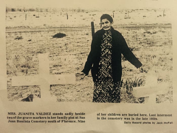"Mrs. Juanita Valdez stands sadly beside two of the grave markers in her family plot at San Juan Bautista Cemetery south of Florence. Nine of her children are buried here. Lat internment in the cemetery was in the late 1950s."