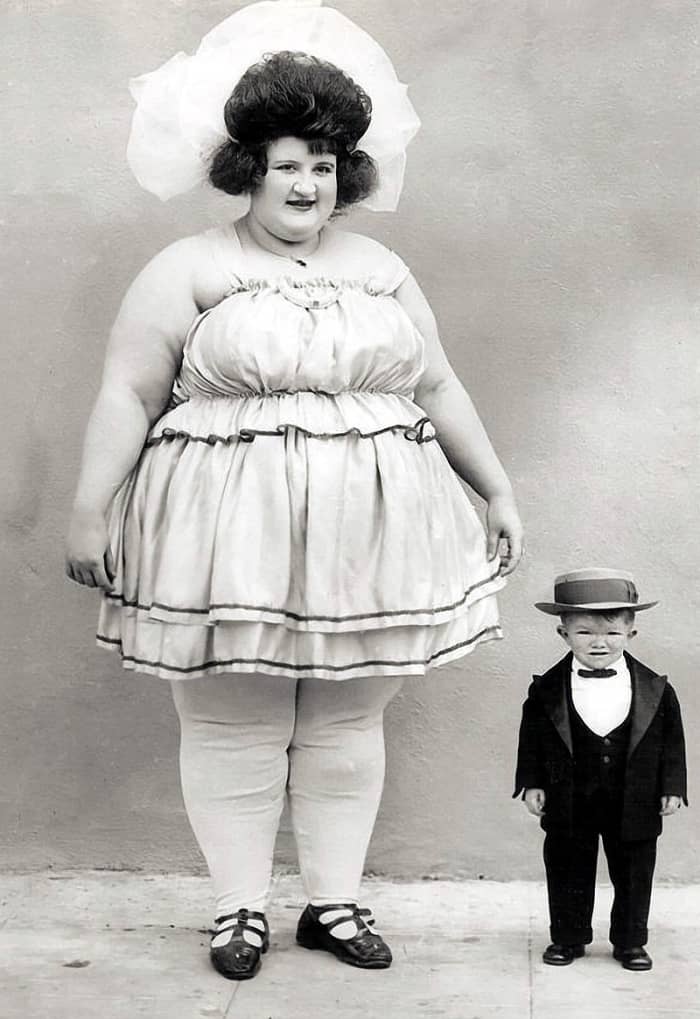 Clarence Howerton grew to be two feet four inches tall. In this image next to a lady billed as the world's biggest woman he is only nine years old.
