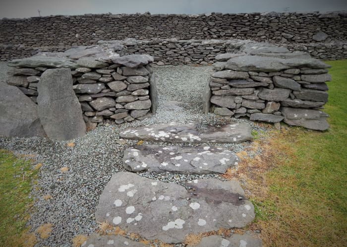 Remains of a clochán ("beehive" hut) with decorated stone pillar to left of entrance, Riasc