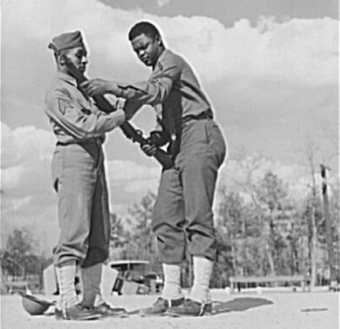 Sgt Williams showing a soldier how to handle his rifle