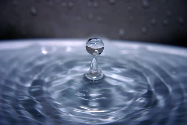 The two major properties of water that make it undesirable as a refrigerant are its high boiling point and high freezing point.