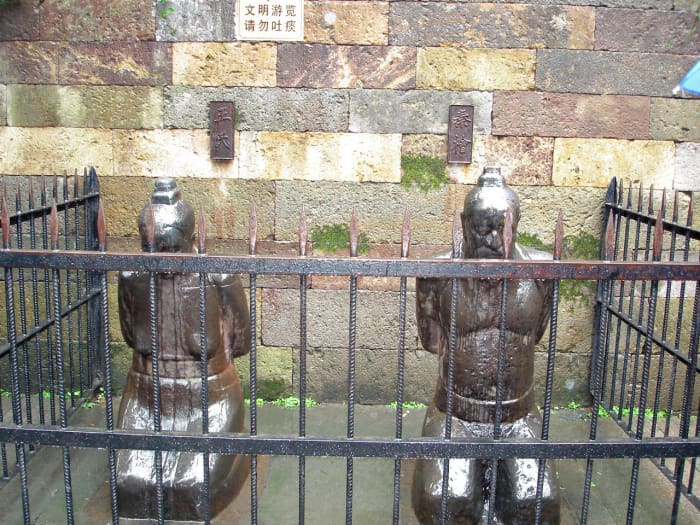 Kneeling statues of Qin Hui and his wife at the Mausoleum of General Yue Fei Tomb, Hangzhou. They are the antithesis of Yue Fei, representing corruption and greed.