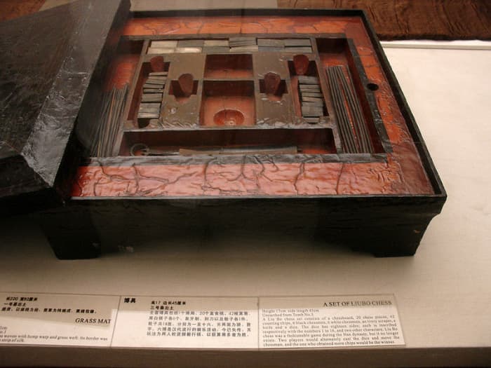 A lacquered Chinese liubo board game set excavated from Tomb No. 3 of Mawangdui, Changsha, Hunan province, China, c. 2nd century BCE. The set featured a lacquered game box, lacquered game board, 12 cuboid ivory pieces, 20 ivory game pieces, 30 rod-sh