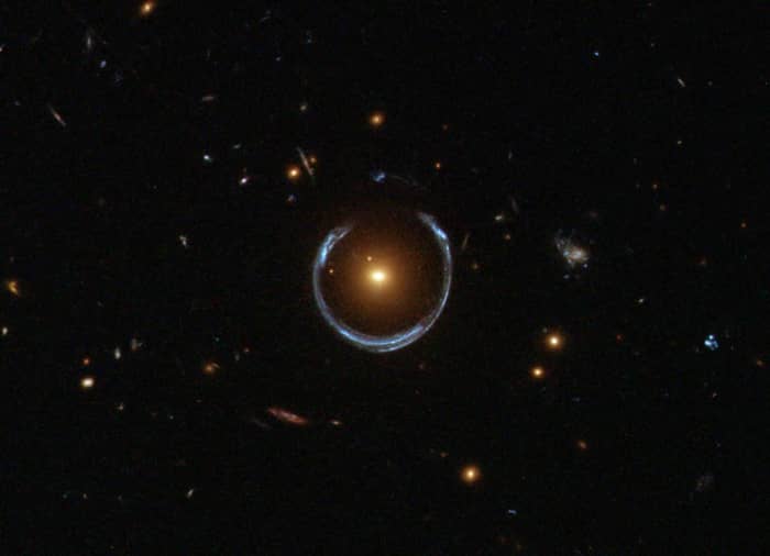 An image from the Hubble Space Telescope showing the characteristic 'Einstein ring' pattern produced by gravitational lensing. The red galaxy acts as a lens for light from a distant blue galaxy. A distant exoplanet would produce a similar effect.