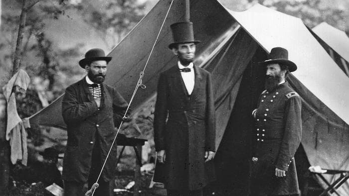Abraham Lincoln standing outside a military tent with Allan Pinkerton and General McClernan
