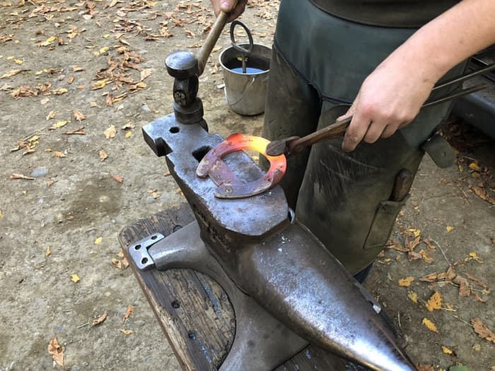 This horseshoe is made of iron. The farrier makes it really hot in a forge so that it gets soft like toffee and can be hammered and bent to the shape he wants.