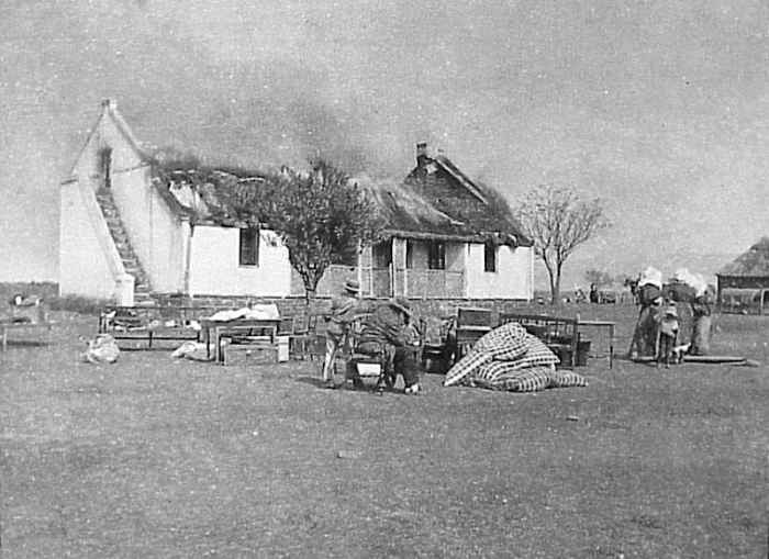 One British response to the guerrilla war was a 'scorched earth' policy to deny the guerrillas supplies and refuge. In this image Boer civilians watch their house as it is burned.