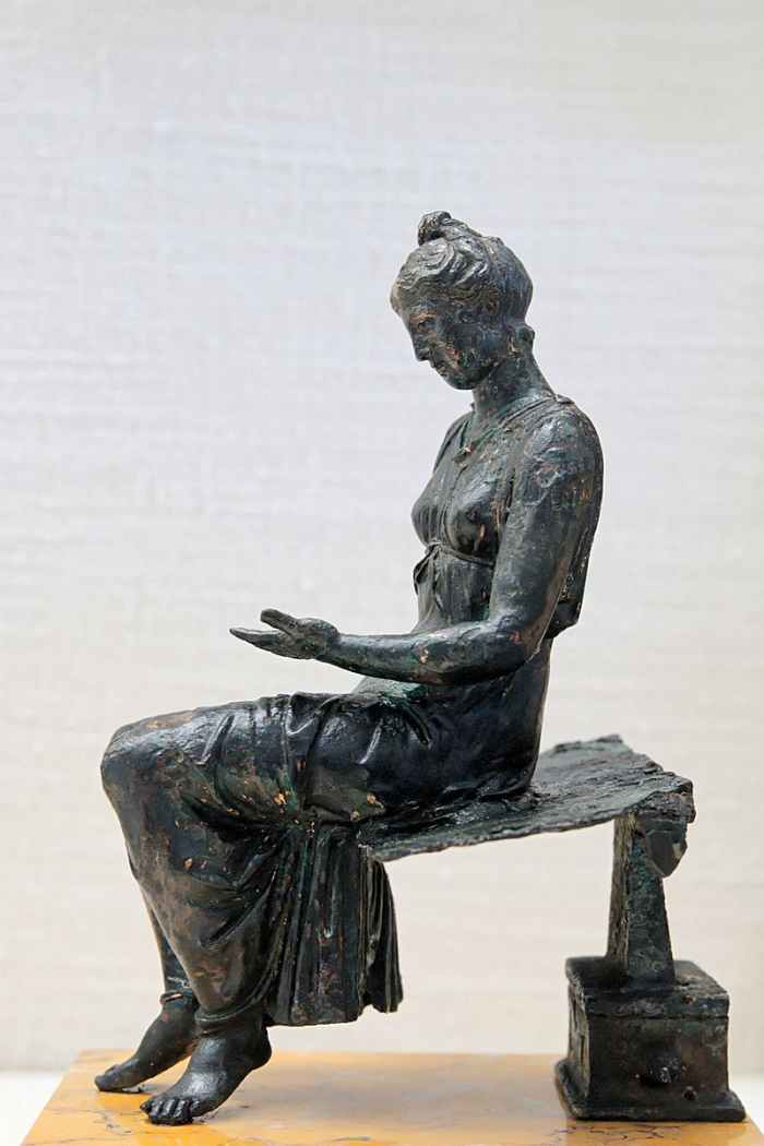 Statuette of girl reading in ancient Rome. Notice the artist's attention to detail in this statue.