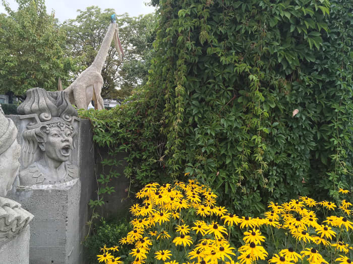 An unusual combination: sculptures of characters from Italian operas, black-eyed Susan flowers, Boston ivy leaves, and a Quetzalcoatlus model in the background