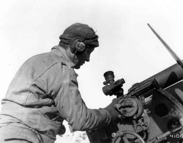 No. 1 gunner on a 105mm (M2). He's to the right of the breech responsible for elevating the gun and attaching the firing pin. Top of the safety plate can be seen upper right.