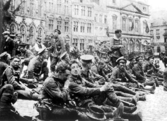 WW1: British soldiers resting in the square at Mons, waiting for the German First Army. August 1914. It would be 4 1/2 years and the last day of the war before Mons was retaken.