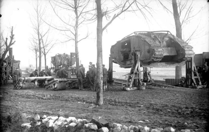 German soldiers prepare to load a British Mark I tank, captured at Cambrai, onto a flat bed rail car. Circa November 1917