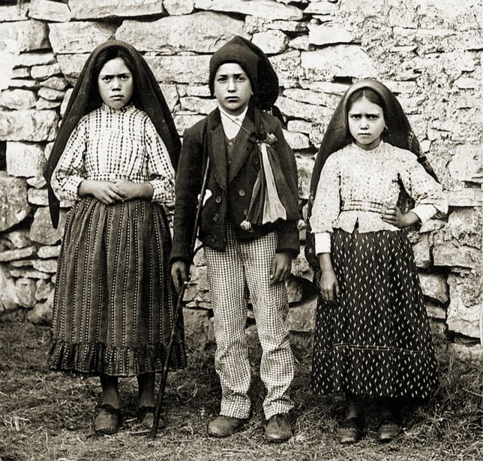 Lucia de Santos is on the left with her cousins, Francisco and Jacinta Marto.
