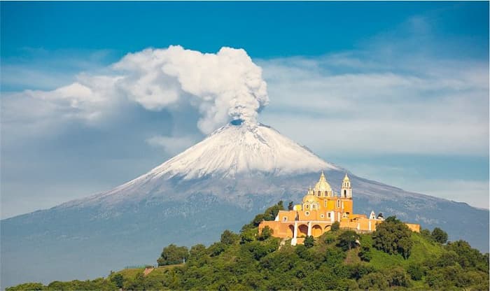 Popocatépetl in the background with La Iglesia de Nuestra Senora de los Remedios in the foreground.