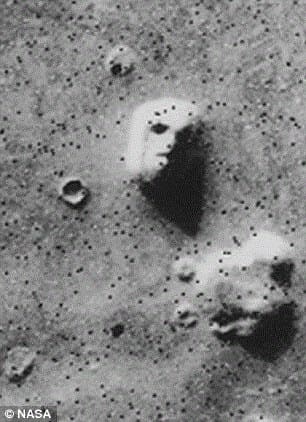 A satellite photo of a mesa in Cydonia, often called the Face on Mars. Later imagery from other angles did not include the shadows.