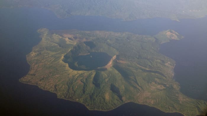 This aerial photo clearly depicts the water-filled caldera from an ancient supervolcano eruption. Today, the body of water is known as Lake Taal.
