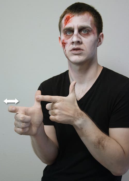 Version 1: The left hand is held thumb up and the index finger hooked on the thumb of the right hand. The right index finger then bends and extends quickly.