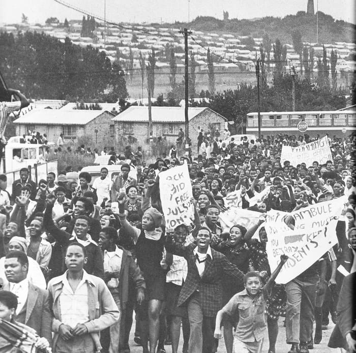 A large column of students marching in an orderly manner and in high spirits carrying their placards, which were simple and to the point messages