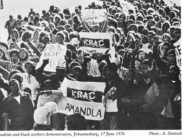Students and Black workers march on Jun 17th 1976 carrying placards and denouncing police might('Krag') written in Africans and crossed with an "X:.