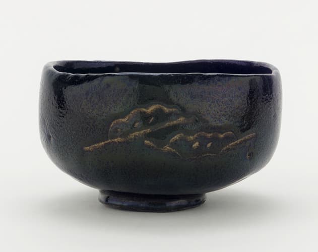 A 17th or 18th century-era chawan with pine boughs and interlocking circles on display at the Freer Gallery of Art in the Smithsonian Institution, Washington, DC, USA. This piece was made in an unknown raku kiln in Kyoto.