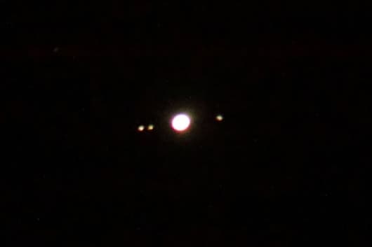 Jupiter and three of its moons. The image is not clear, but deliberately so, as it shows what you are likely to see of Jupiter's moons if you use simple binoculars. (In my binoculars, the planet and moons appear a bit sharper than this, but fainter