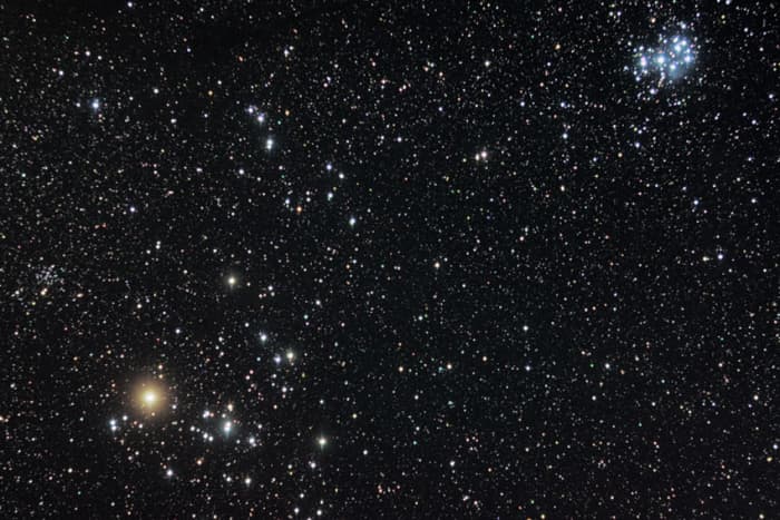 The Hyades and Pleiades in the constellation Taurus. The bright orange star is Aldebaran. Immediately right of Aldebaran is the cluster of stars which make up the Hyades. In the top right is the more conspicuous Pleiades