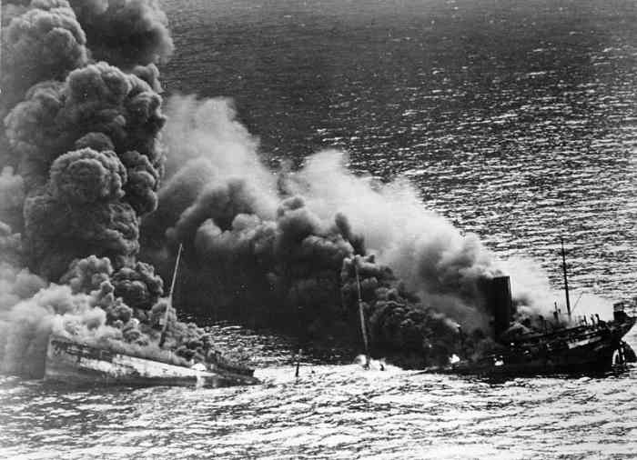 WW2: Allied tanker torpedoed in Atlantic Ocean by German submarine. Ship crumbling amidship under heat of fire, settles toward bottom of ocean. March 26, 1942.
