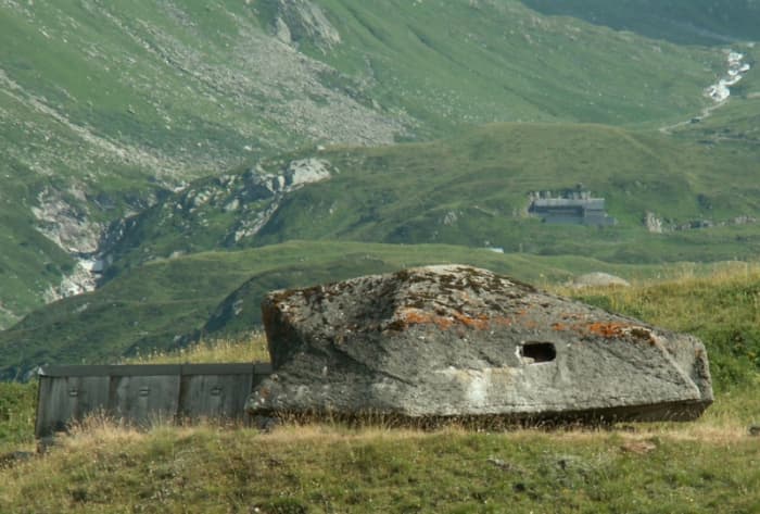 Camouflaged cannons and fortifications near Furka Pass in the Gotthard region. Note the fortress embedded in the hillside in the distance.