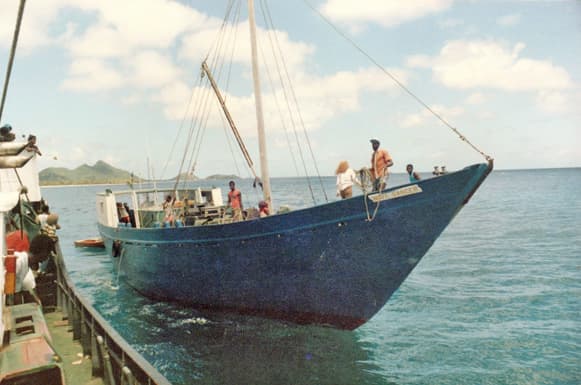 Water transports boats of all sizes filled with people, mail, and physical goods. Taken in the West Indies, 1985.