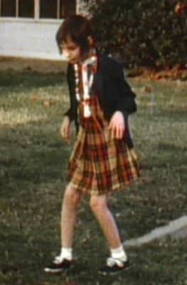 Genie demonstrating her curious way of walking, with her hands held in the same way as a rabbit. This peculiar form of walking came about as a result of the abuse she suffered from her father.
