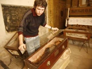 A caretaker at the catacombs overlays a second sheet of glass over Rosalia's coffin for added protection.