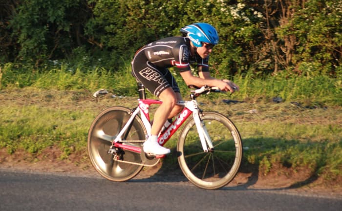 Chasing a fast time in a cycling time trial is a sign of competitiveness and is a behavior driven by achievement motivation.