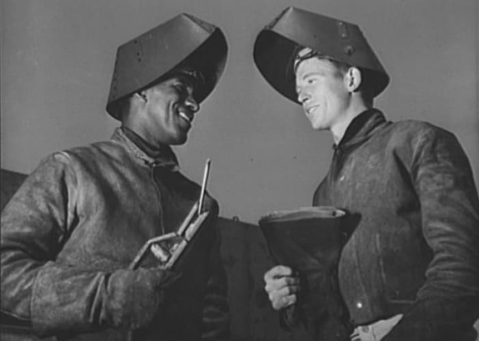 Original 1942 caption: Jesse Kermit Lucas, experienced Negro welder at the California Shipbuilding Corporation's yards, is shown instructing his white welder apprentice, Rodney Gail Chesney, as the two work on the "Booker T. Washington"