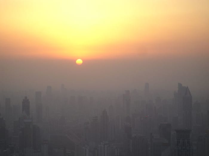 The setting sun reaches the 'smog line' above Shanghai, February 9, 2008. Photo by Suicup, courtesy Wikimedia Commons.