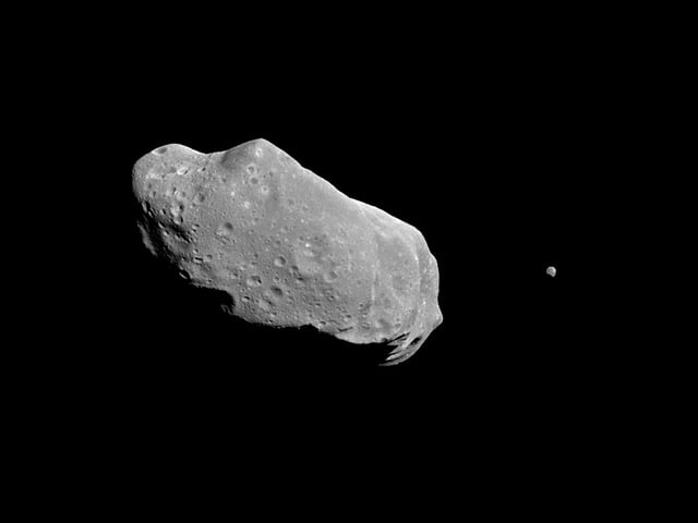 An asteroid is a mass of matter in space. This asteroid is the first known to have a satellite (the small object in the right of the photo.)
