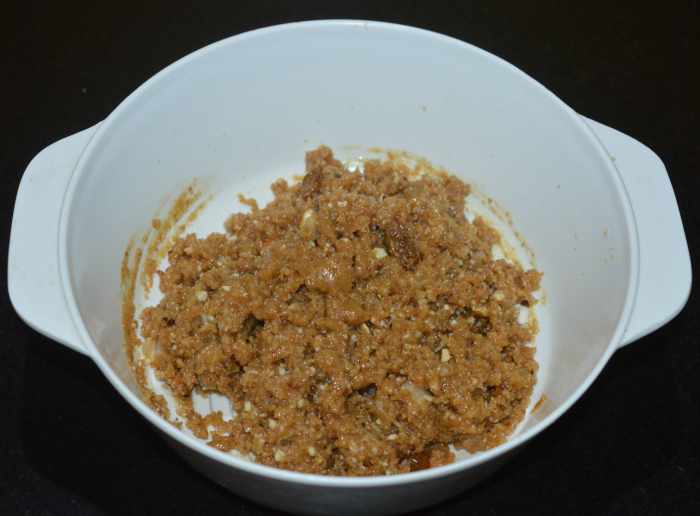 Mix the contents with a spoon. When the mixture cools, take a lemon-sized portion in your fist and form a ball while pressing all the sides. Place it on a plate. Similarly, make all the balls (laddus). 