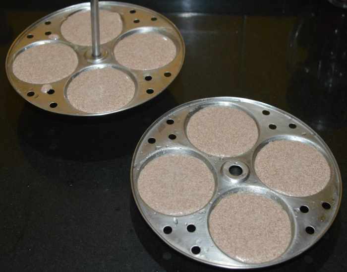 Step four: Add 2-3 tablespoons of the batter into each idli mould. Arrange the idli stand.