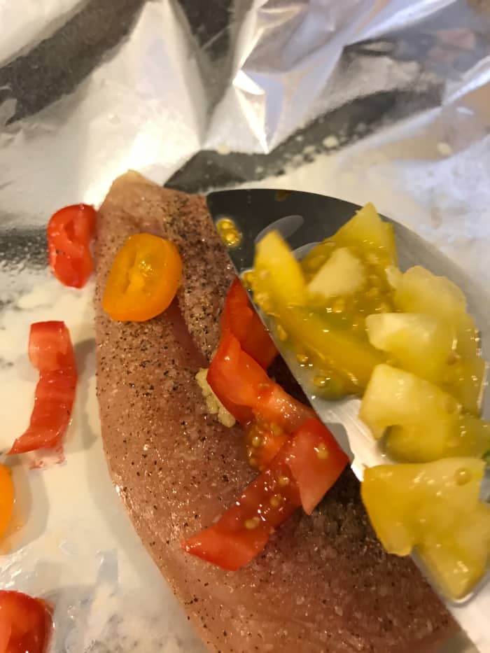 Use your favorite fresh vegetables for even more flavor. I used diced cherry tomatoes here. Cut small, they release their liquids into the packet, adding to the sauce that develops as the chicken cooks.