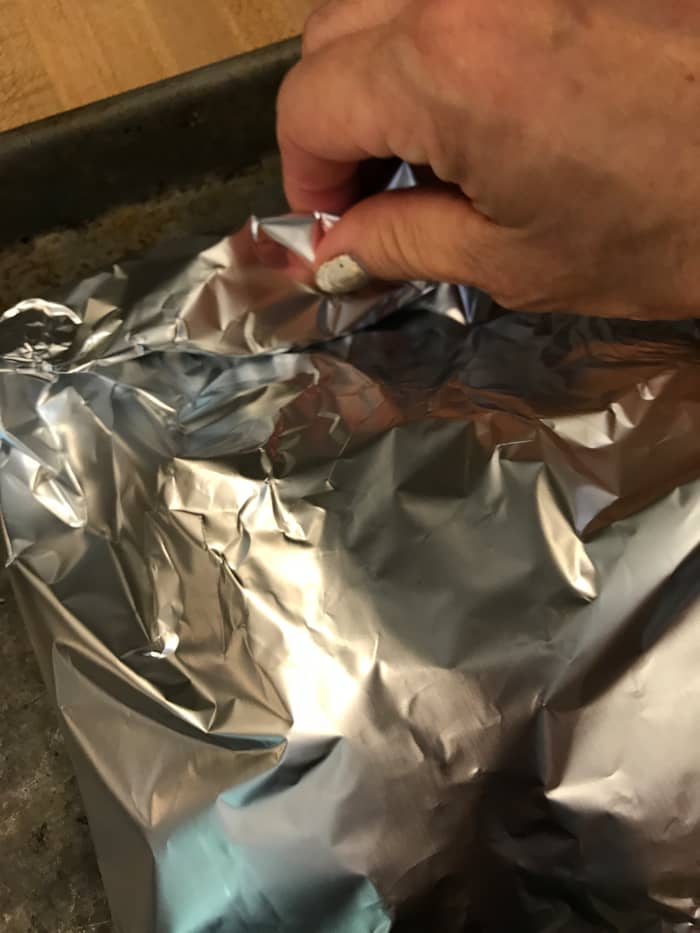 If you use parchment paper, fold up the edges and wrap a couple of times, or use butcher's twine to make a 'purse'. With foil, simply roll and crimp the edges to seal the packet.