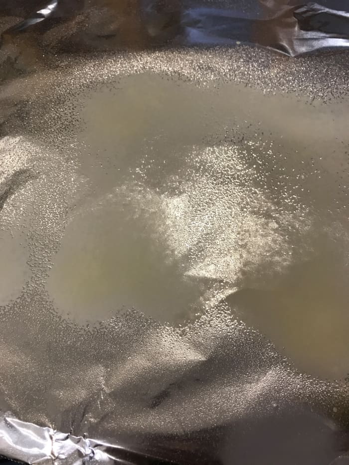 Use just a little bit of butter on the parchment or foil, or in this case, plain cooking spray. The food steams in the packet, so this is simply to prevent the chicken from sticking to the foil or parchment.