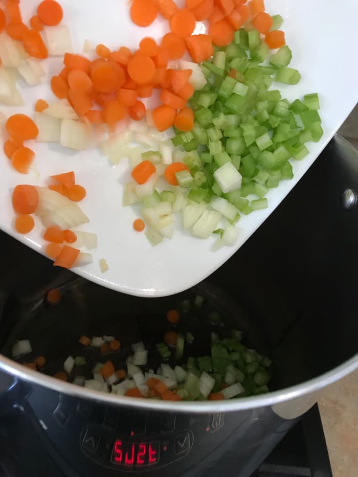 Use just a couple tablespoons of olive oil, and saute the vegetables over medium heat for about ten minutes, or until the vegetables are tender and fragrant. Don't over cook them - you want some firmness so they don't end up mushy after simmering.