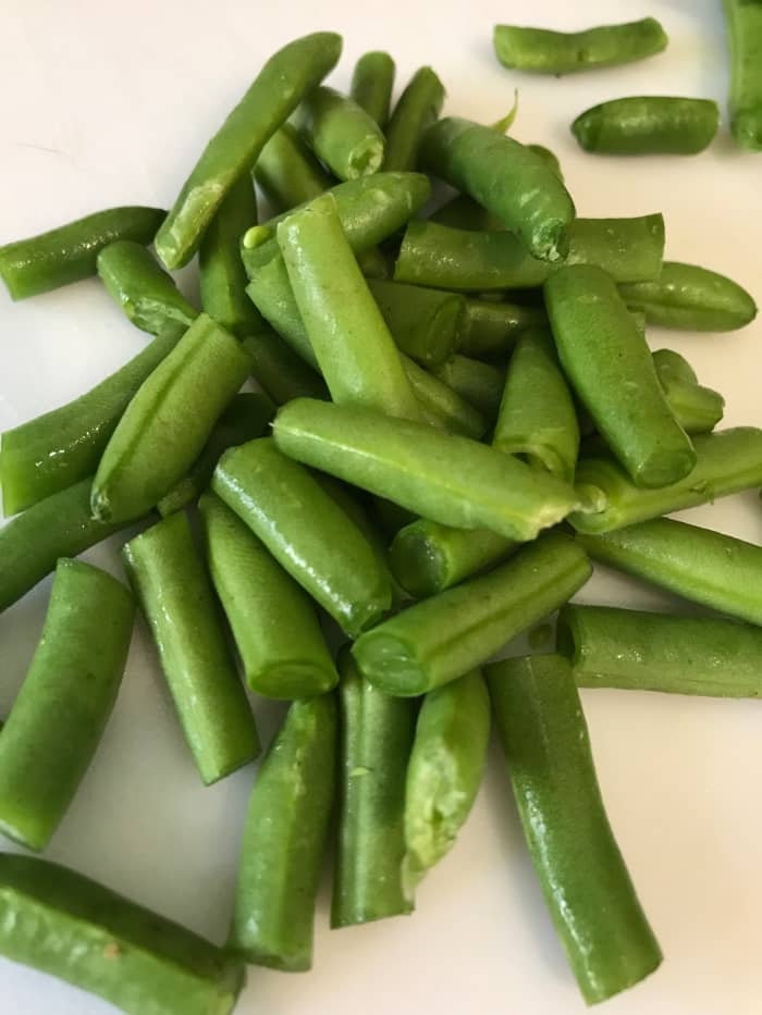 Add cut green beans right as you add the pasta. They'll cook in the broth, but not over cook, since the pasta takes only ten minutes. This leaves them crisp tender and perfect in the finished soup.