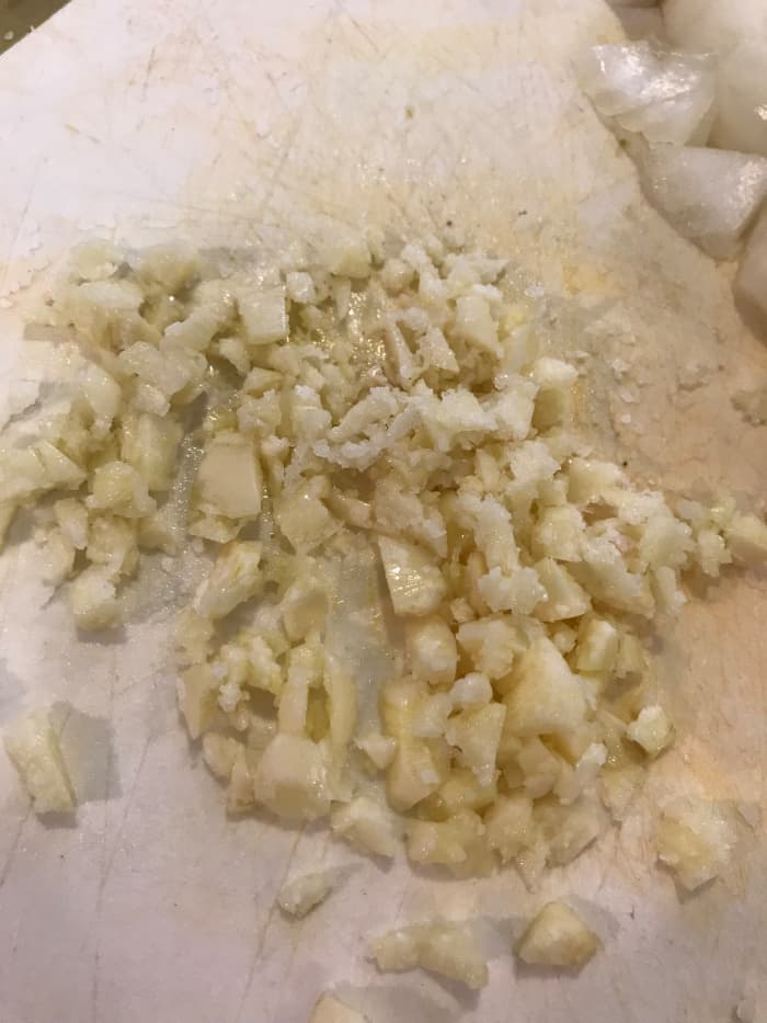 Because the garlic will cook for a long period of time, it will become sweeter and nuttier. I like to mince it, and add it after the veggies to help prevent the risk of burning it. Mince it with a little salt and olive oil to make mincing easier.