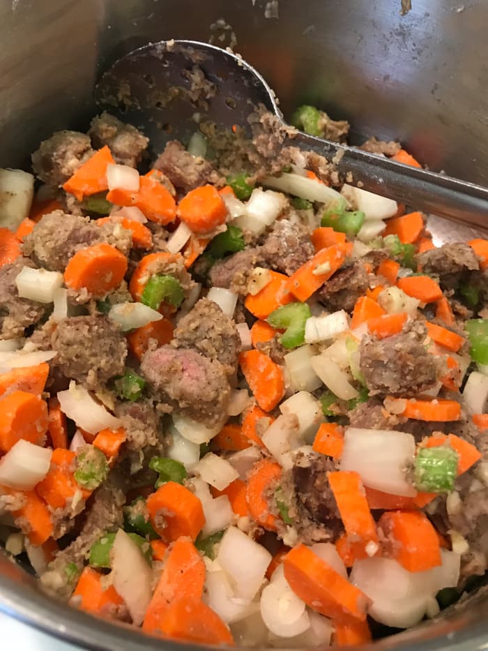 Stir the vegetables into the beef/flour mixture. You can let it cook for a minute or two at this stage, but the vast majority of the cooking will be after the liquids are added. Throw the garlic in after the vegetables are added.