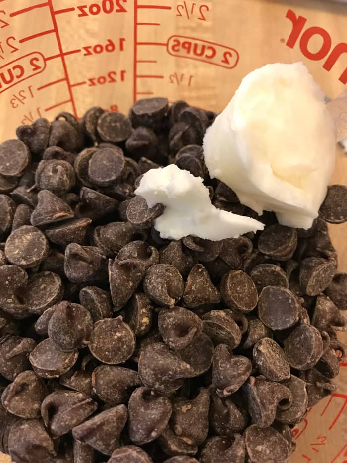Using a little shortening while melting chocolate makes it melt a bit more easily, helps keep it from seizing, and makes it easier to use for dipping. Just zap it in the microwave for a few seconds at a time.