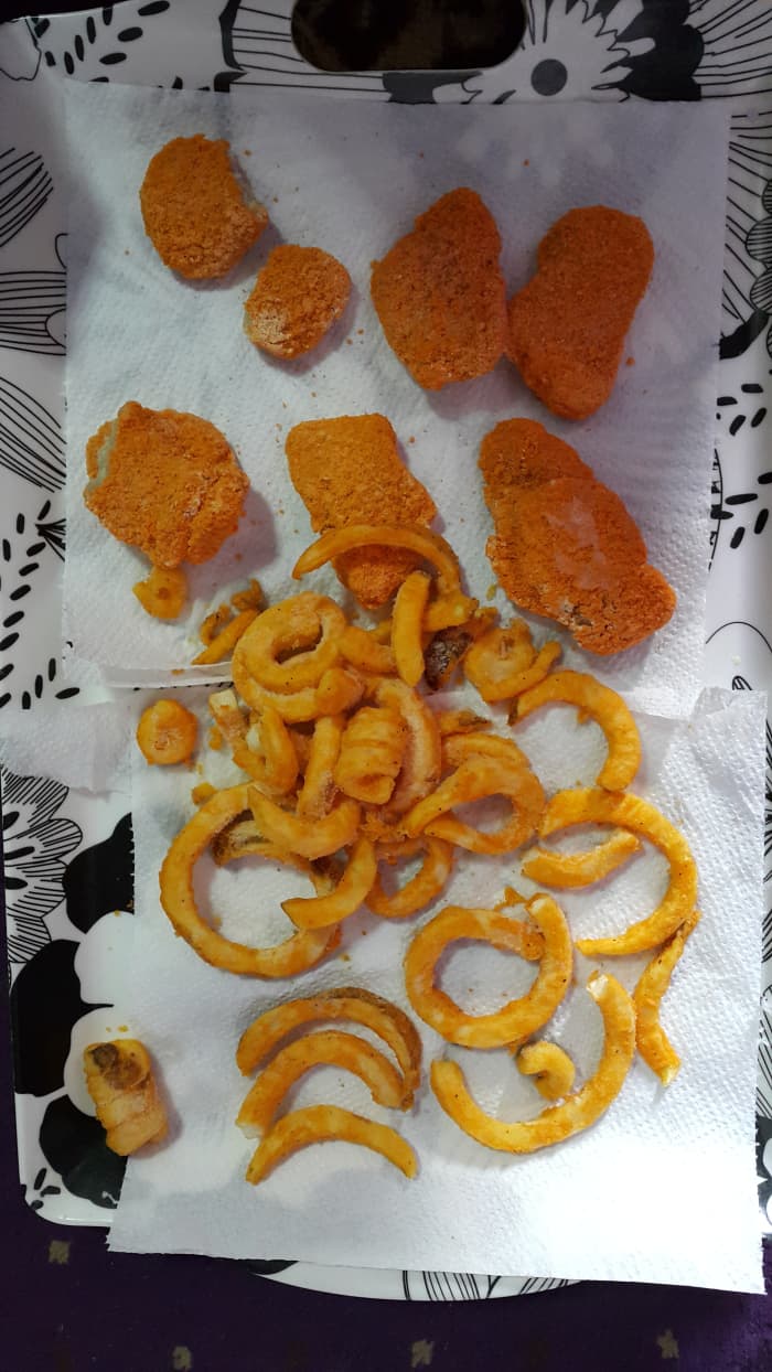 Before frying, spread the chicken nuggets and curly fries on an absorbant paper towel/tissue paper.
