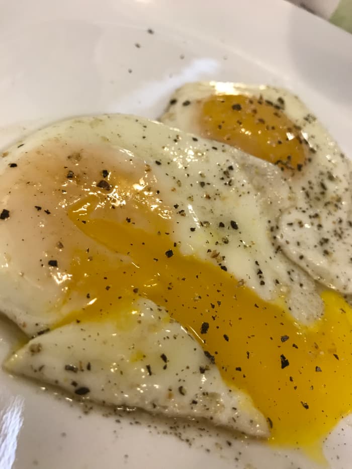 A perfectly cooked, sunny-side-up egg. Tender, well done whites, a warm, runny yolk, and perfect pepper!