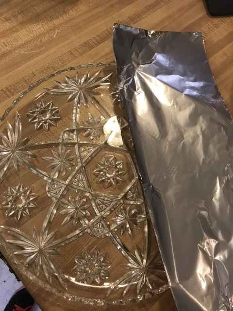 Prepare a cake plate by placing strips of foil along the edges, making sure to leave the center of the plate uncovered. Place a dollop of frosting in the center of the plate.