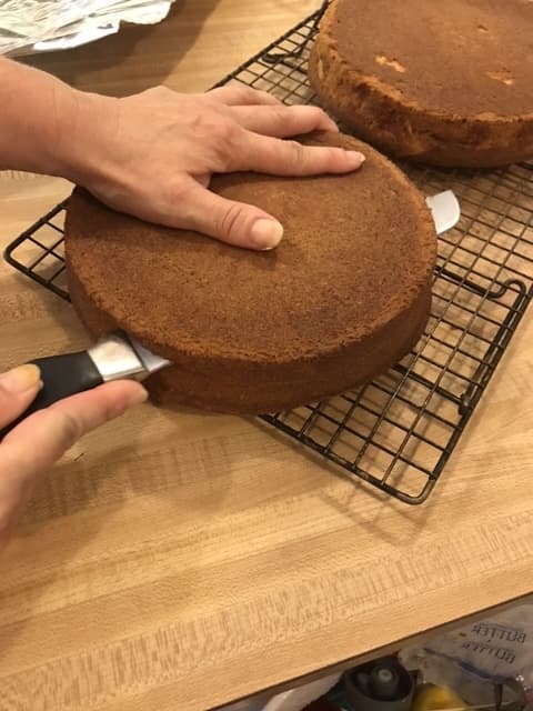 With a serrated knife, cut each cake in half horizontally. Separate the cut halves and set one aside. Just try to keep the knife as even as possible, but don't worry too much about it.
